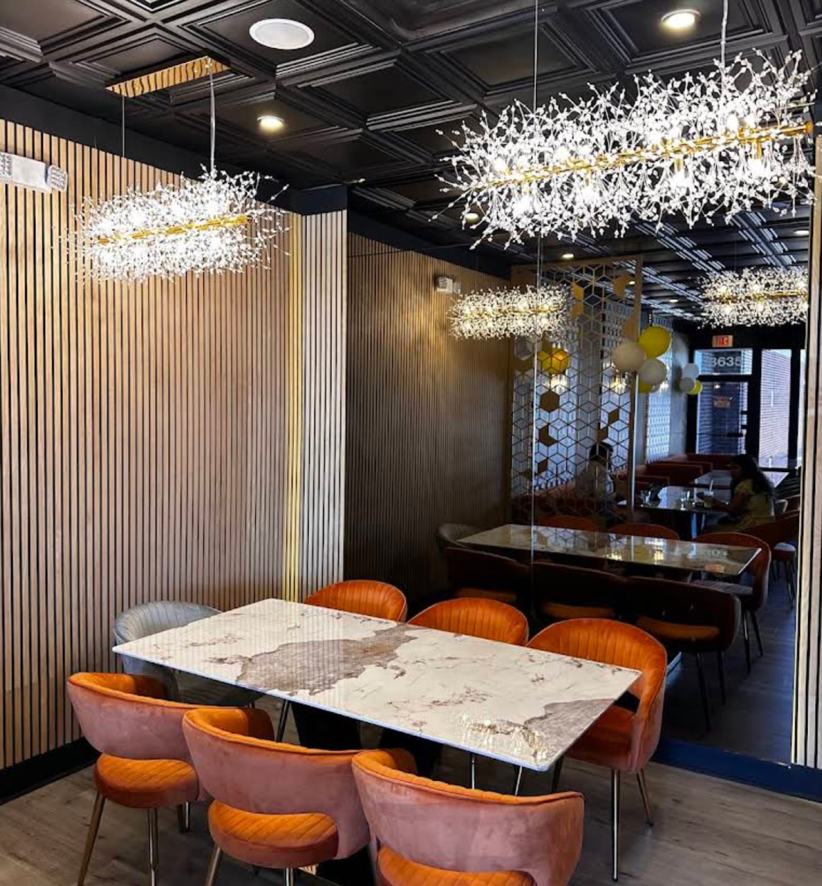 Semi-private dining alcove with crystal branch chandeliers and marble table